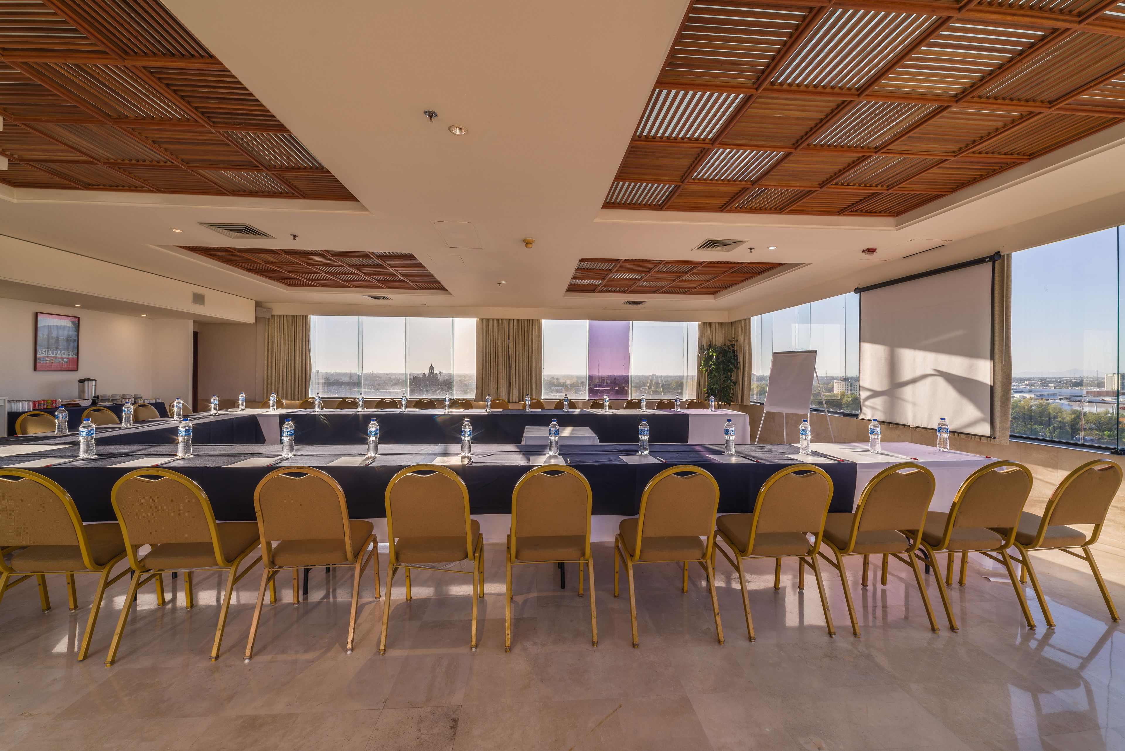 Une salle de conférence dotée d’une longue table, de nombreuses chaises et de grandes fenêtres donnant sur la ville.