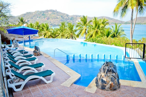 Una piscina al aire libre, sombrillas