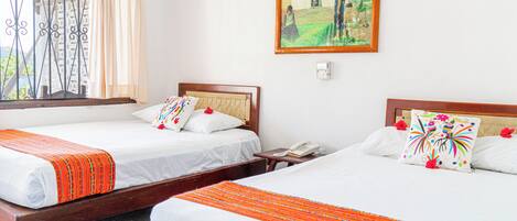 Two single beds with wooden frames, white bedding, and orange decorative borders.