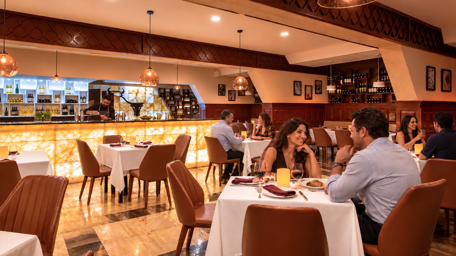 A restaurant with a bar area, multiple tables, and chairs.