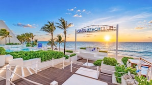 A resort with a pool, lounge areas, and a view of the ocean at sunset. - The Grand Oasis Cancun - All Inclusive (Cancun)