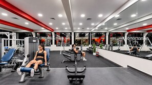 A gym with various exercise equipment, mirrors, and a red and white color scheme. - The Grand Oasis Cancun - All Inclusive (Cancun)