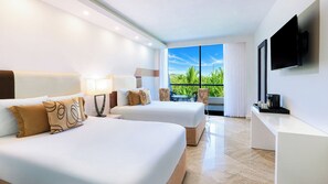 A hotel room with two beds, a TV, a balcony with a view of greenery, and a coffee machine. - The Grand Oasis Cancun - All Inclusive (Cancun)