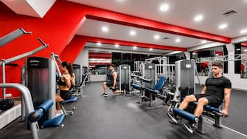 A gym with various exercise equipment, a red and white color scheme, and a modern design.