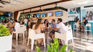 A modern restaurant with white chairs and tables, a bar area, and a menu board. - The Grand Oasis Cancun - All Inclusive (Cancun)