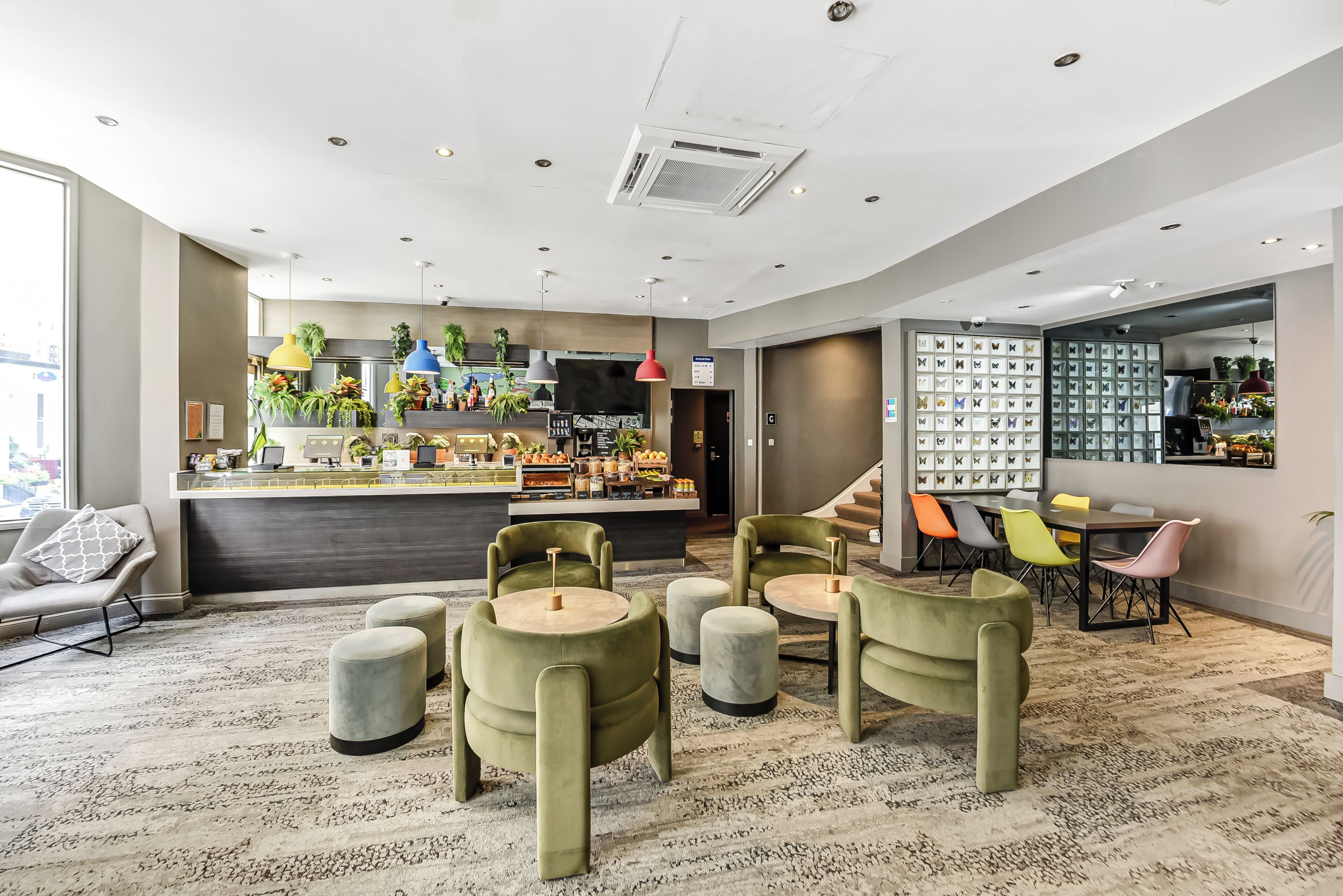 A modern hotel lobby with a bar area, seating, and a display of shoes.