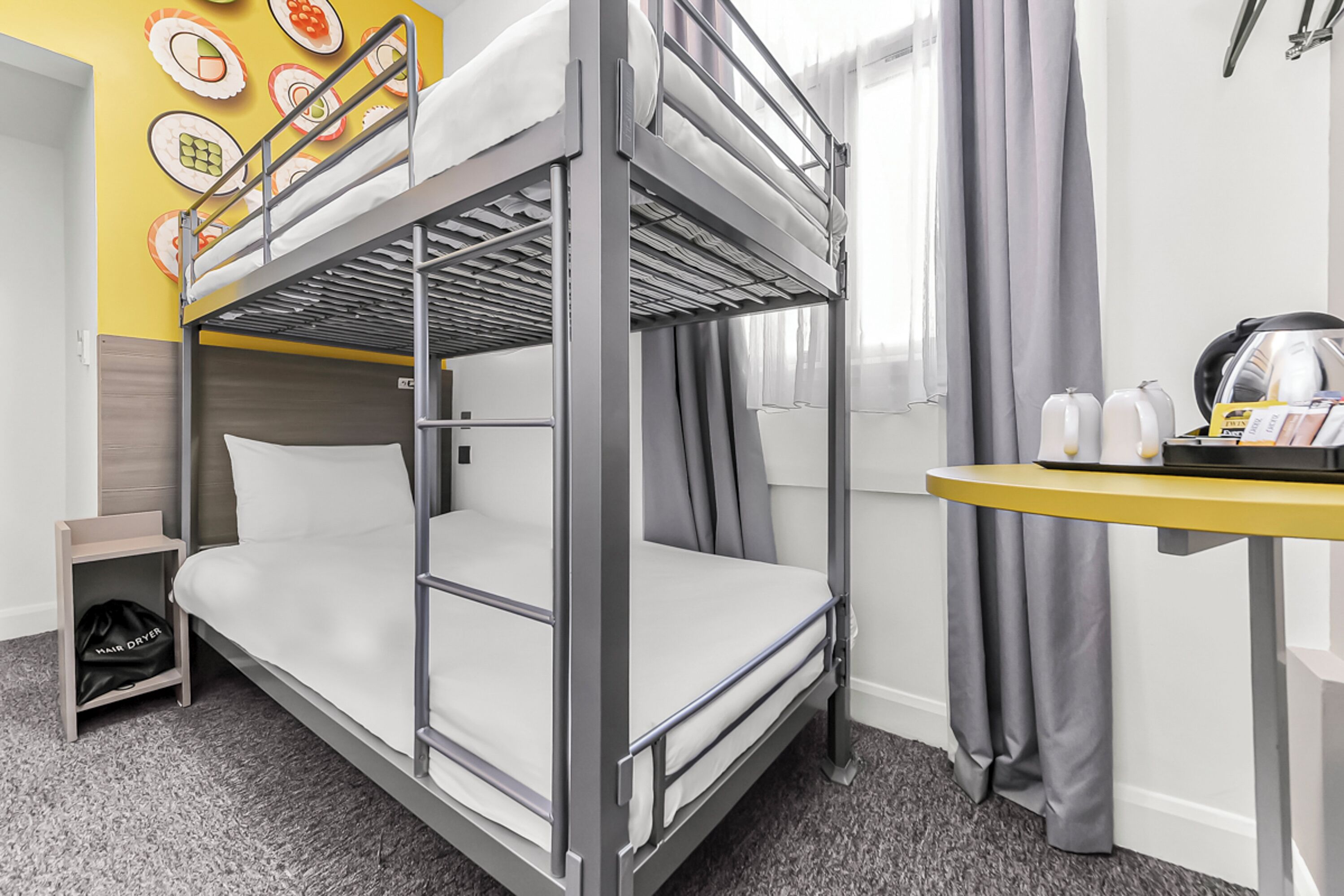 A bunk bed with a desk and a hair dryer.