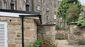 Un bâtiment en pierre avec un jardin à l’avant.
