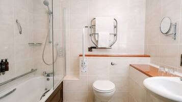 A modern bathroom with a glass-enclosed shower, a toilet, and a sink with a wooden countertop.