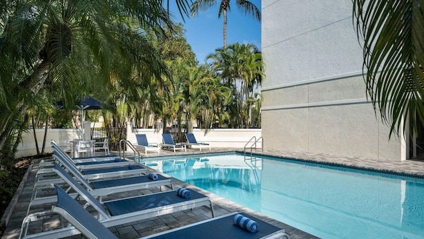 A pool area with lounge chairs and a clear blue pool.