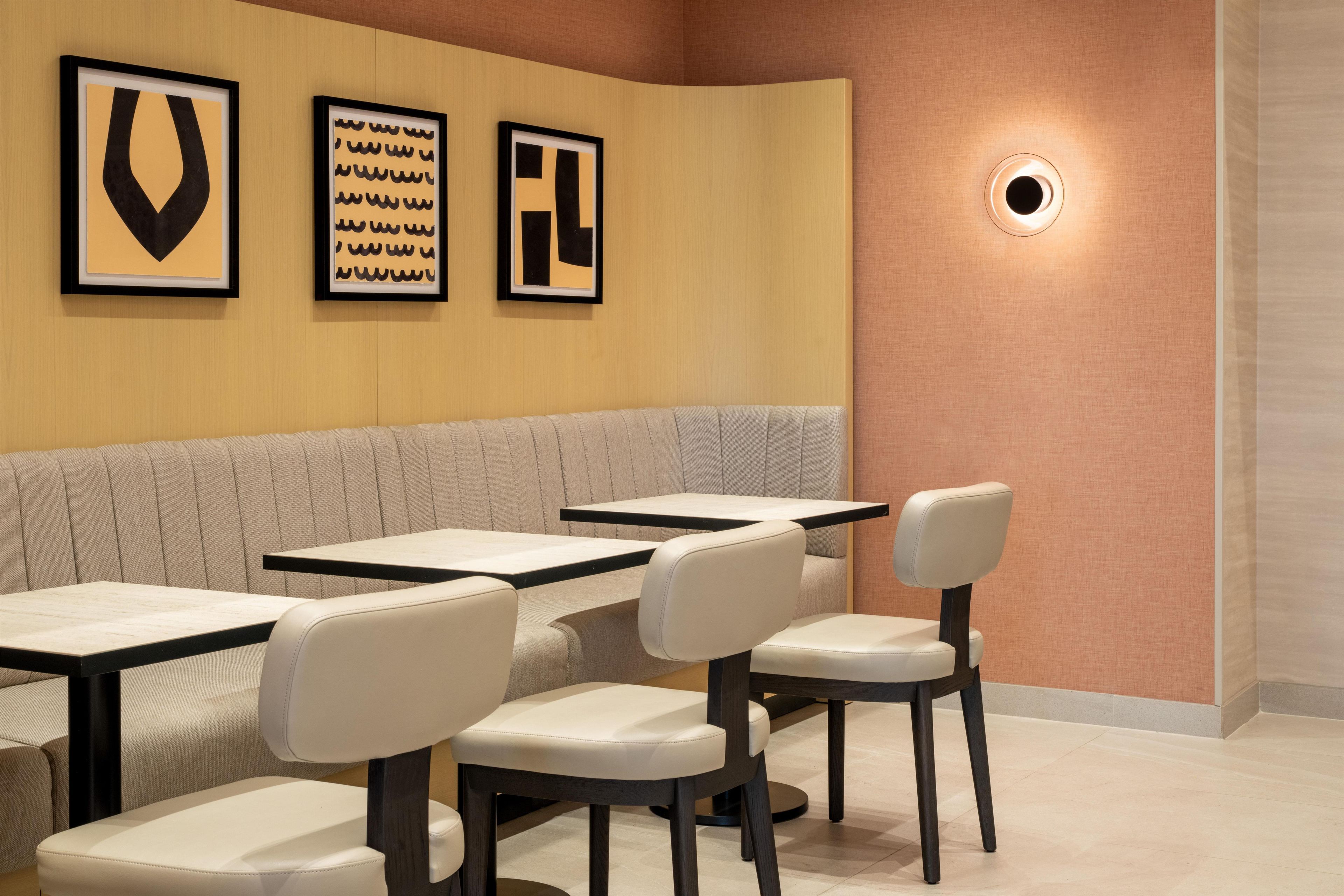 Un interior de restaurante con una zona de cabinas y mesas individuales.