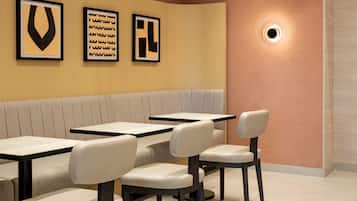 Un interior de restaurante con una zona de cabinas y mesas individuales.