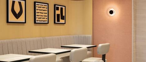 Un interior de restaurante con una zona de cabinas y mesas individuales.