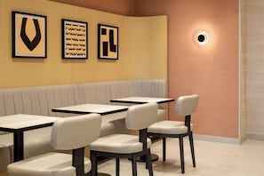 L'intérieur d'un restaurant avec des banquettes et des tables individuelles.