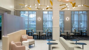 Un intérieur moderne avec des espaces de détente, des tables et des luminaires au plafond originaux.