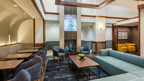 A modern hotel lobby with seating areas, a fireplace, and a view of the city. - Hyatt Place Atlanta/Duluth/Johns Creek (Johns Creek)