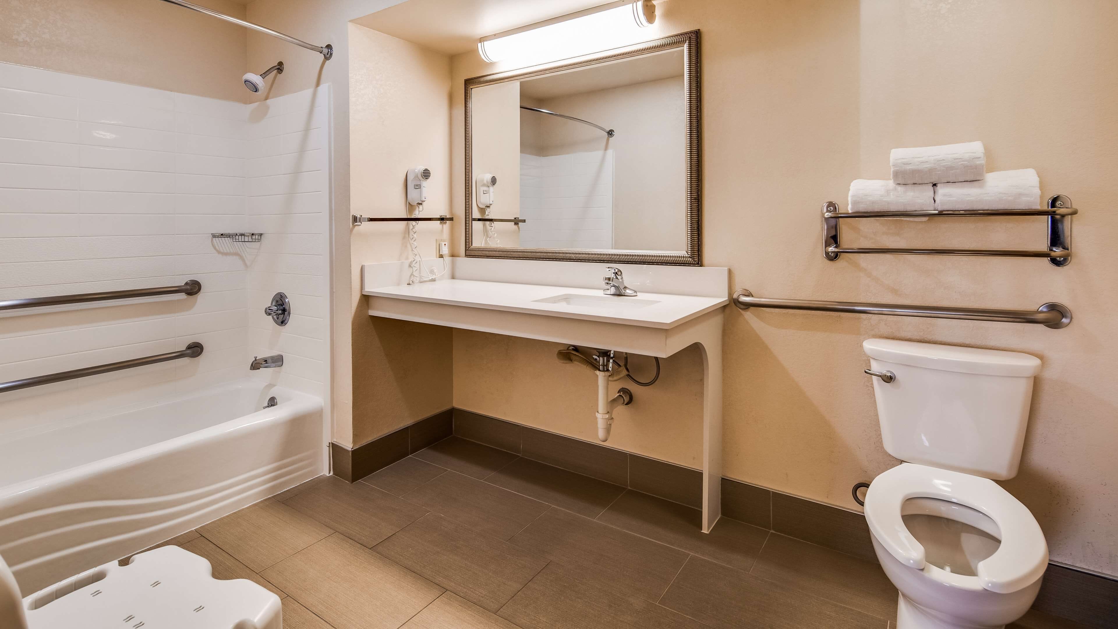 Une salle de bain avec une baignoire, un lavabo, des toilettes et un miroir.