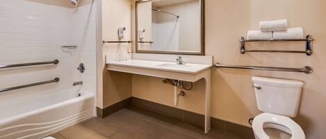 Une salle de bain avec une baignoire, un lavabo, des toilettes et un miroir.