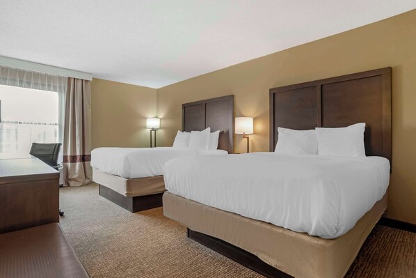 A hotel room with two beds, a desk, and a chair. - Comfort Inn Opelika - Auburn (Opelika)
