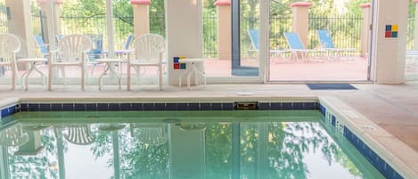 Una piscina techada, sillones reclinables de piscina