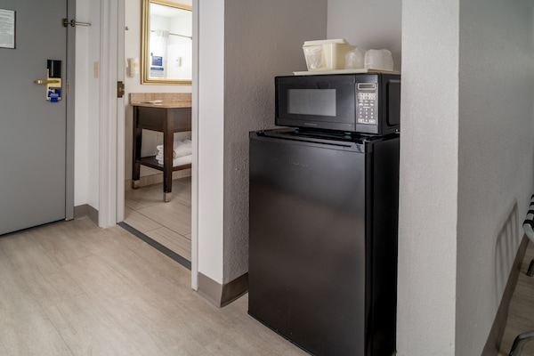 Escritorio, cortinas opacas, tabla de planchar con plancha