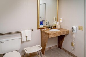 Un baño con inodoro, lavabo y un taburete pequeño.