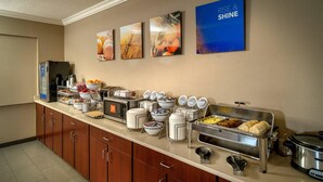 Un buffet con diversi piatti, una macchina per il caffè e una risottiera.