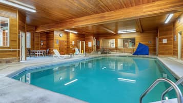 Een binnenzwembad, ligstoelen bij het zwembad