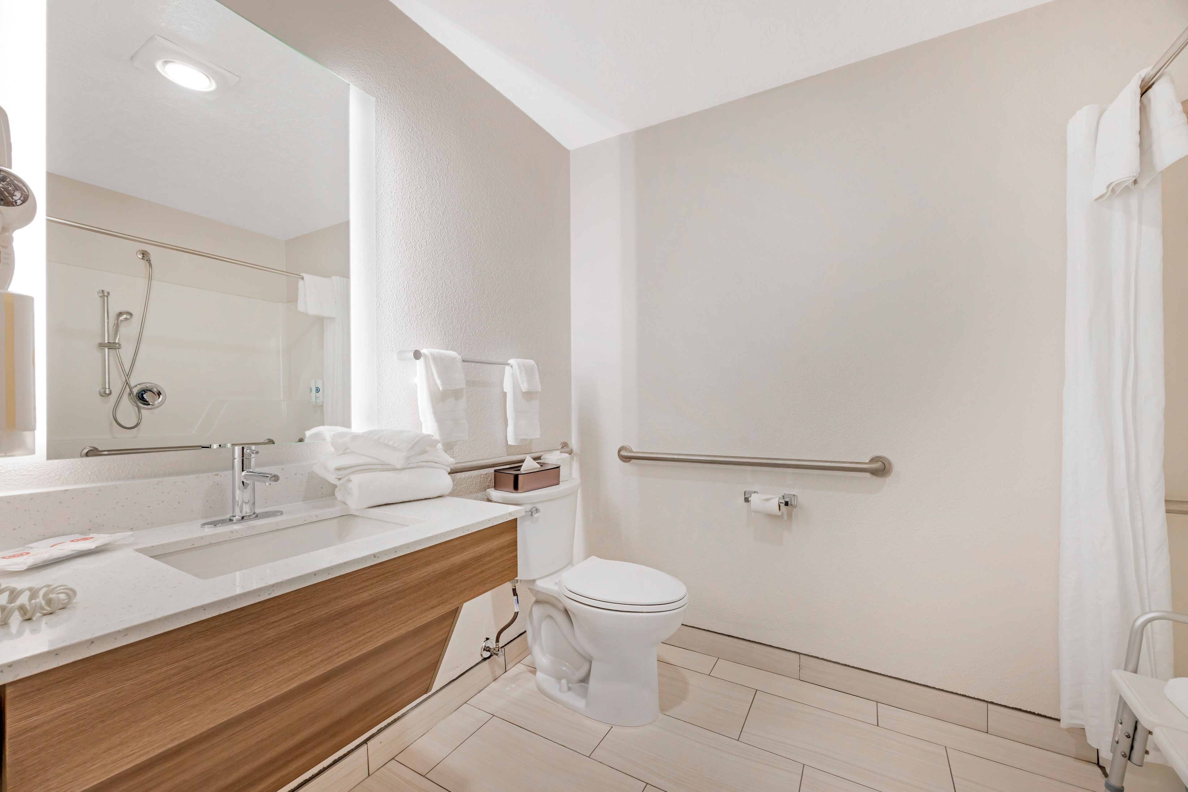 Een moderne badkamer met een douche, toilet en wastafel.