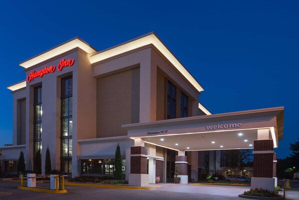 A Hampton Inn hotel entrance with a clearway sign, modern architecture, and illuminated signage.