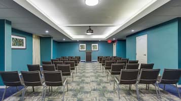 A conference room with rows of chairs, a projector, and a door.
