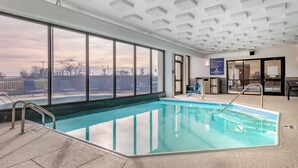 An indoor swimming pool with clear glass walls, a tiled floor, and a ceiling with recessed lighting. - Drury Inn & Suites Champaign (Champaign)