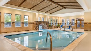 An indoor swimming pool with stone walls, a wooden ceiling, and large windows. - Hilton Vacation Club Lake Tahoe Resort South (South Lake Tahoe)