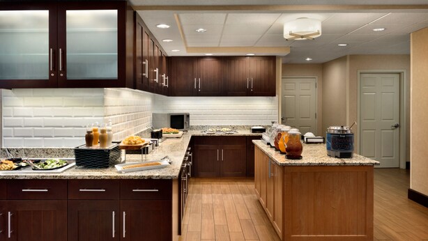 A modern kitchen with dark wood cabinets, a granite countertop, and a central island.