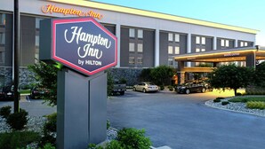 Un Hampton Inn by Hilton con un letrero llamativo, un estacionamiento y una entrada acogedora.