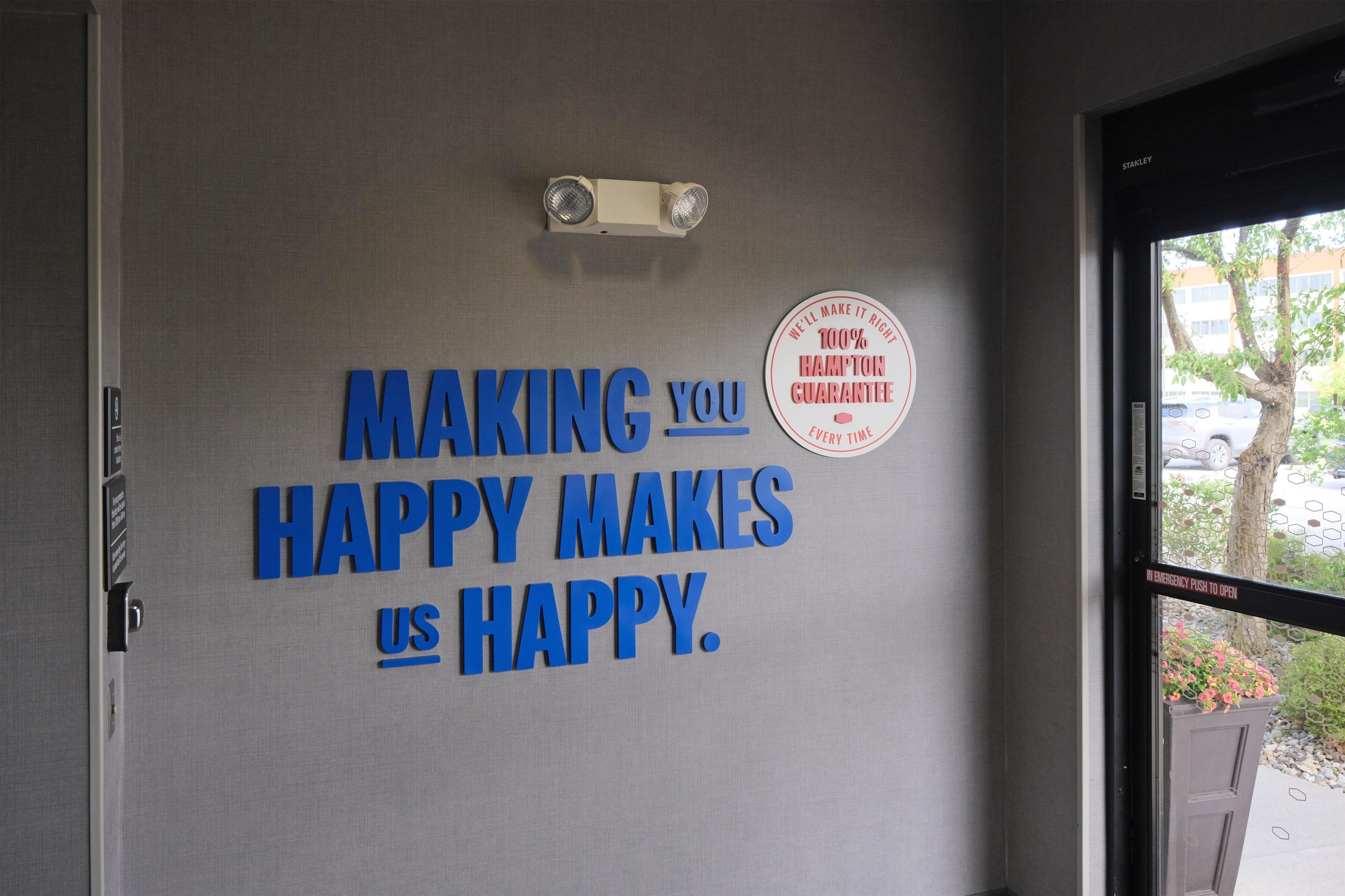 A wall with motivational text and a Hampton Guarantee badge.