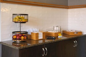 A breakfast bar with fruit baskets, paper towels, and egg cartons.