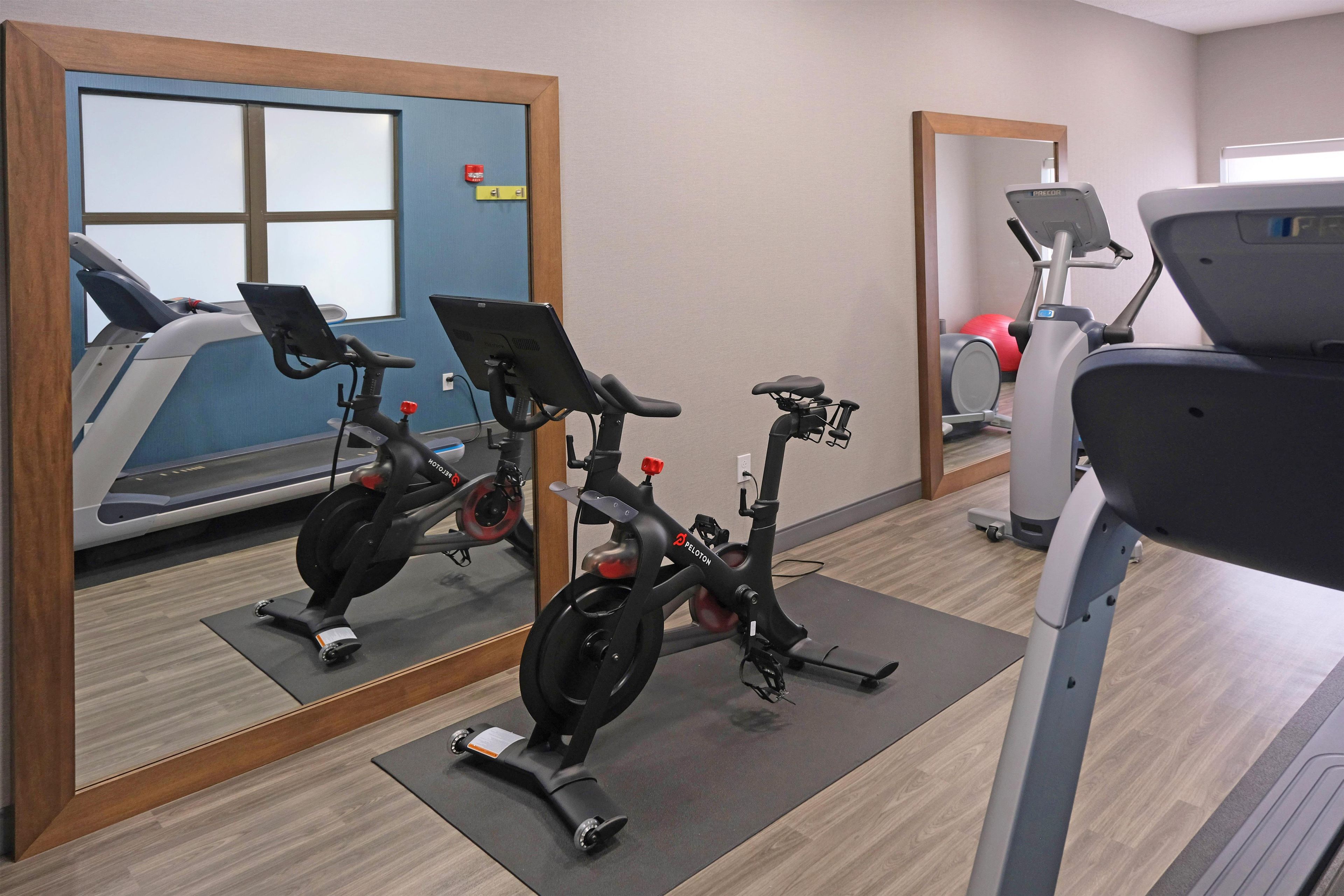 A gym with stationary bikes, a treadmill, and exercise balls.
