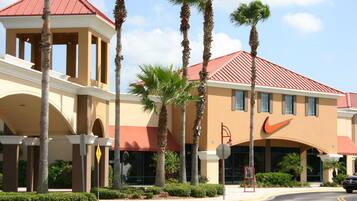 A hotel with a red roof, palm trees, and a Nike logo.