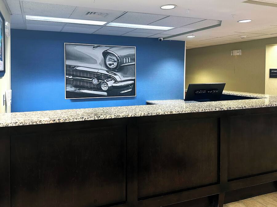 A reception desk with a granite countertop, a laptop, and a wall-mounted security camera.