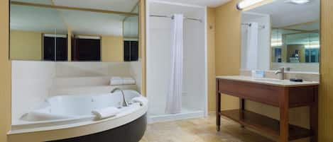 A modern bathroom with a freestanding bathtub, a separate shower area, and a vanity with a mirror.