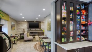 A modern living room with a flat-screen TV, a fireplace, and a snack cabinet. - Best Western North Phoenix Hotel (Phoenix)