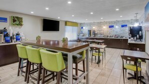 A modern kitchen with a central island, bar stools, and a dining area with chairs. - Best Western North Phoenix Hotel (Phoenix)