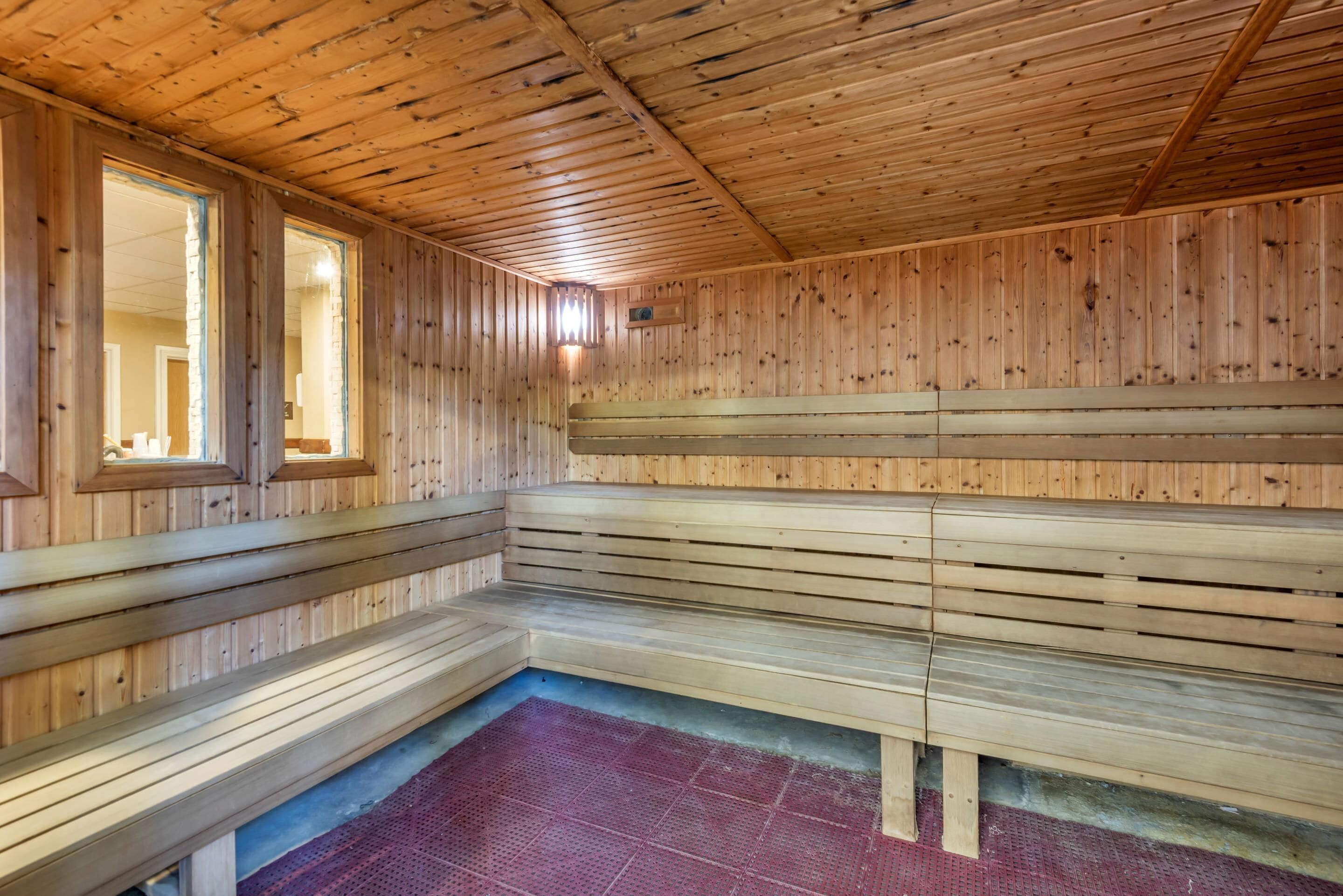 Una sauna con panche in legno e pavimento inclinato.