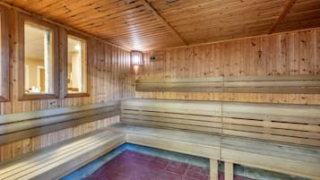Una sauna con panche in legno e pavimento inclinato.