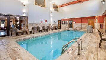 Een binnenzwembad, ligstoelen bij het zwembad