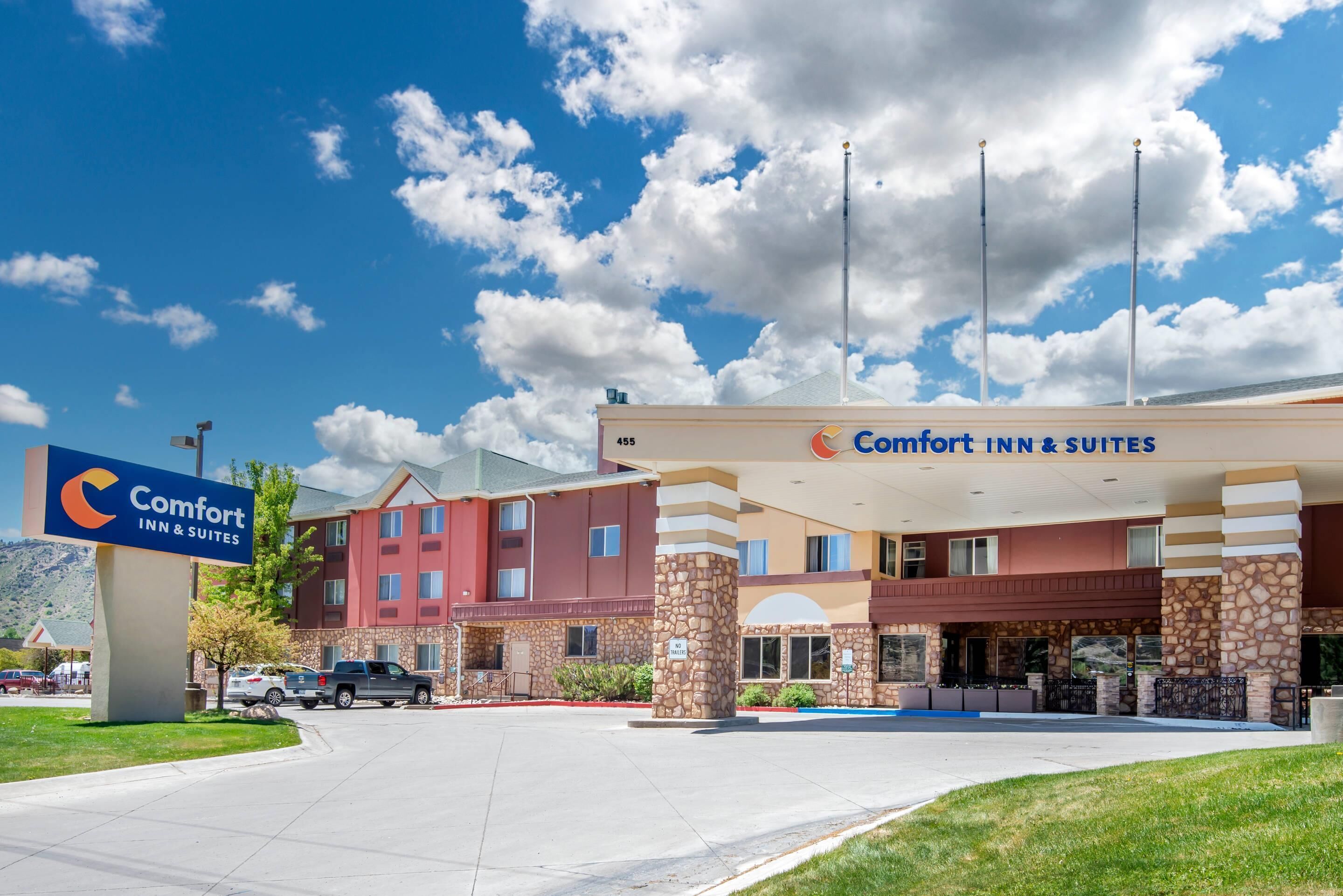 A Comfort Inn & Suites hotel with a stone facade, a large sign, and a parking lot.