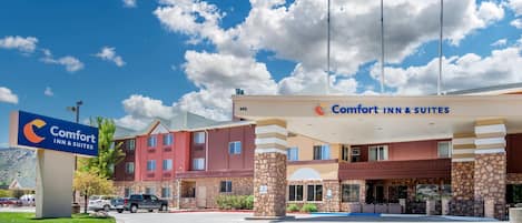A Comfort Inn & Suites hotel with a stone facade, a large sign, and a parking lot.