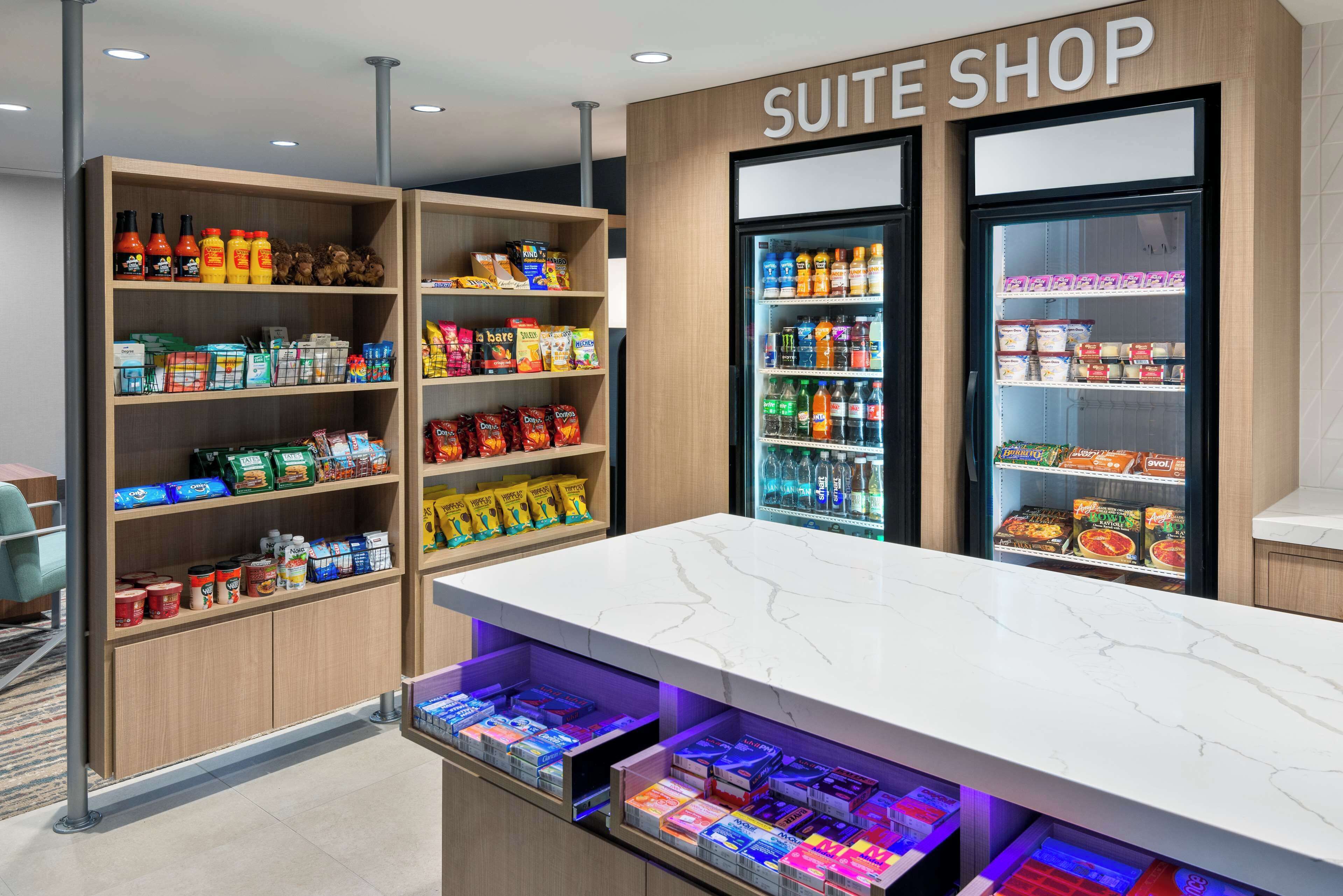 Tienda de suites con estantes llenos de aperitivos, bebidas y productos envasados.