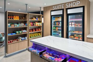 Tienda de suites con estantes llenos de aperitivos, bebidas y productos envasados.